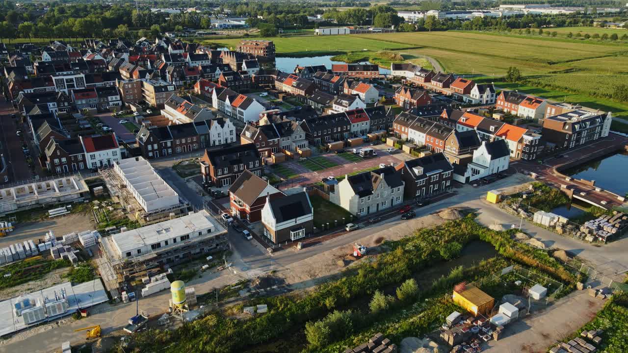 드론이 천천히 현대적이고 새로 지어진 교외 동네에서 멀리 날고 있습니다.