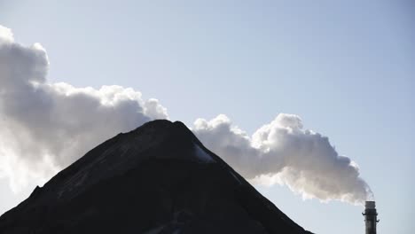 fumar bombeando fuera de pilas de humo industrial en cámara lenta con una colina en el tiro
