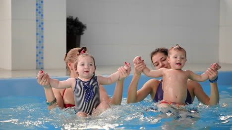 grupo de madres con sus bebés en la clase de natación infantil