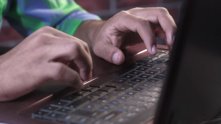 Close-up of a Person Typing on a Laptop Keyboard
