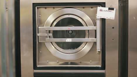 Industrial metal washing machine in action.