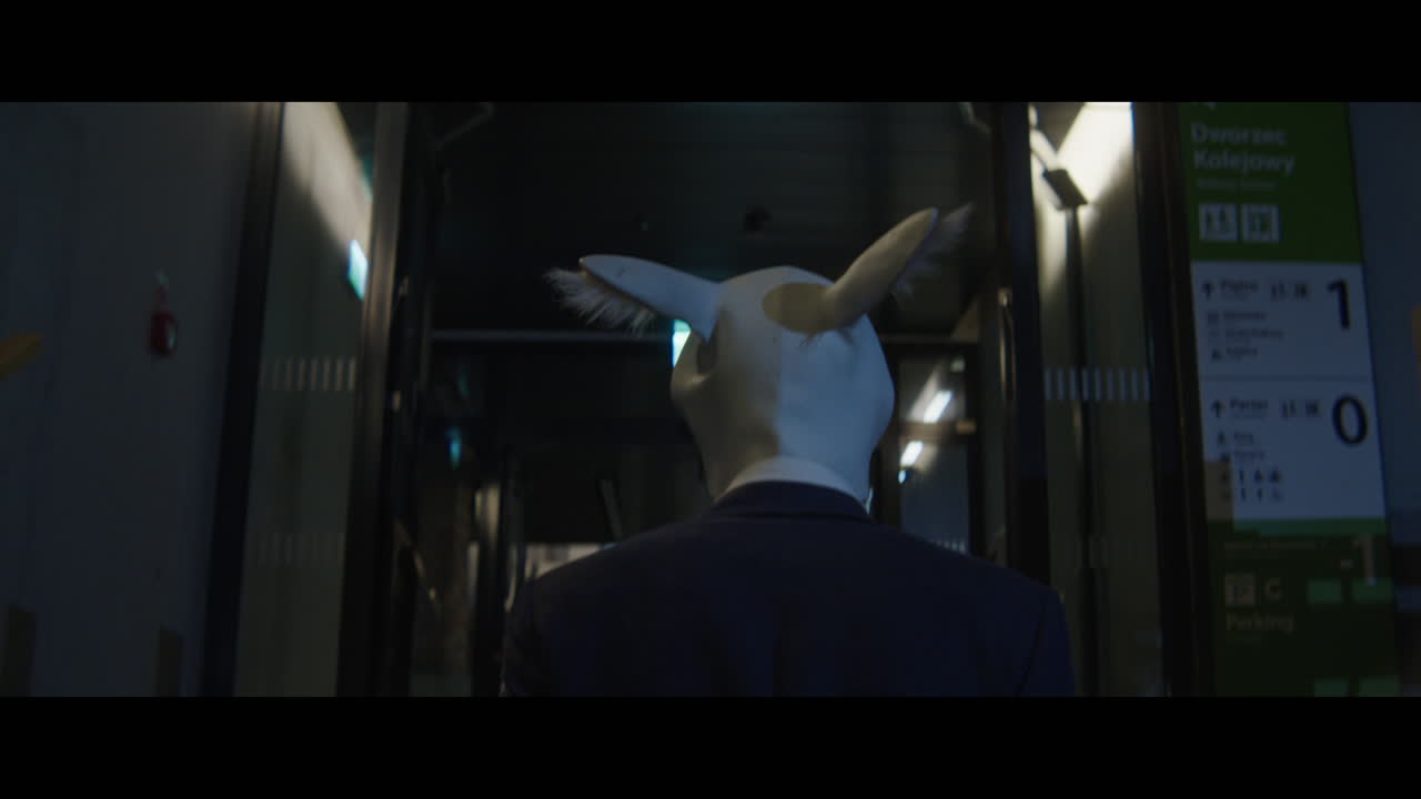 Man walking down a corridor with a rabbit head