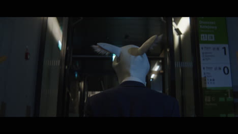 man walking down a corridor with a rabbit head