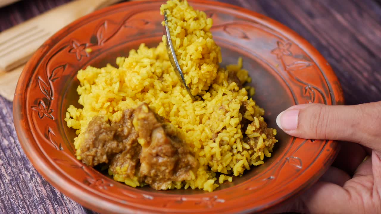 Riso giallo bollito con carni su un piatto