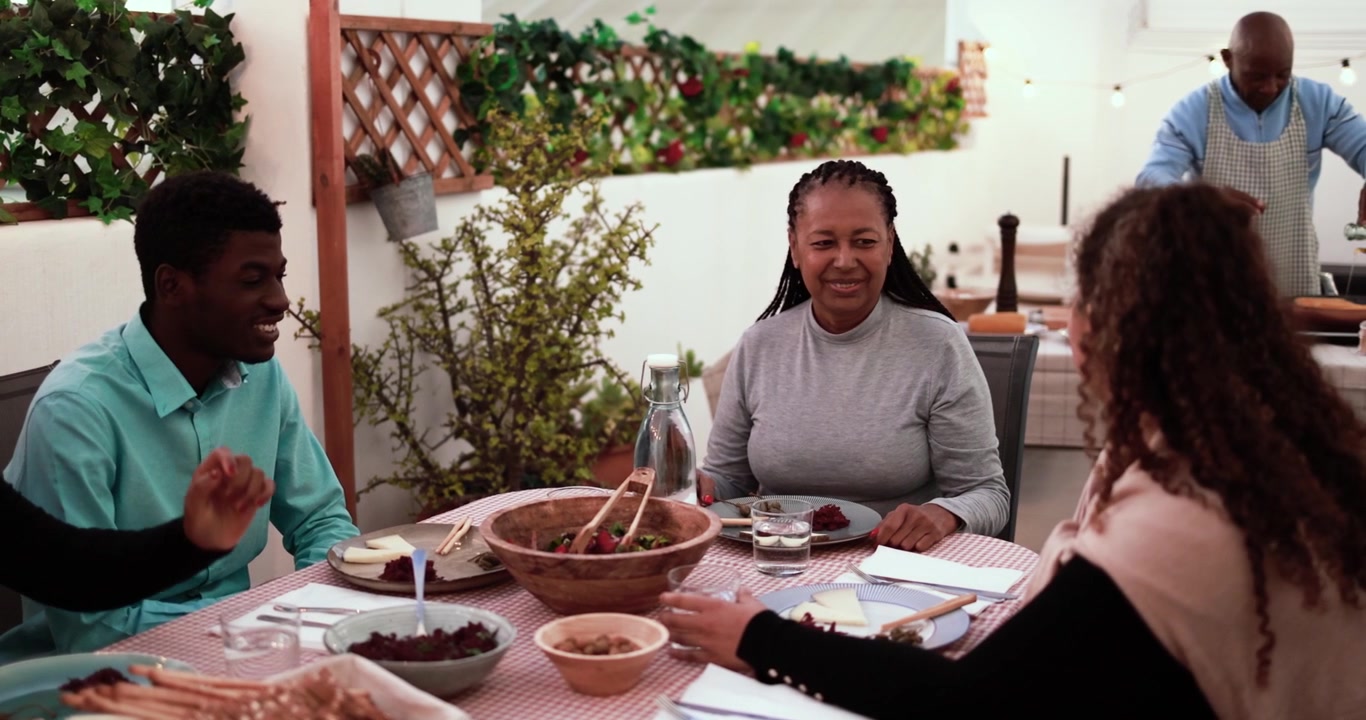 Happy Multi-Generational African Family Enjoying Dinner Together on a Terrace