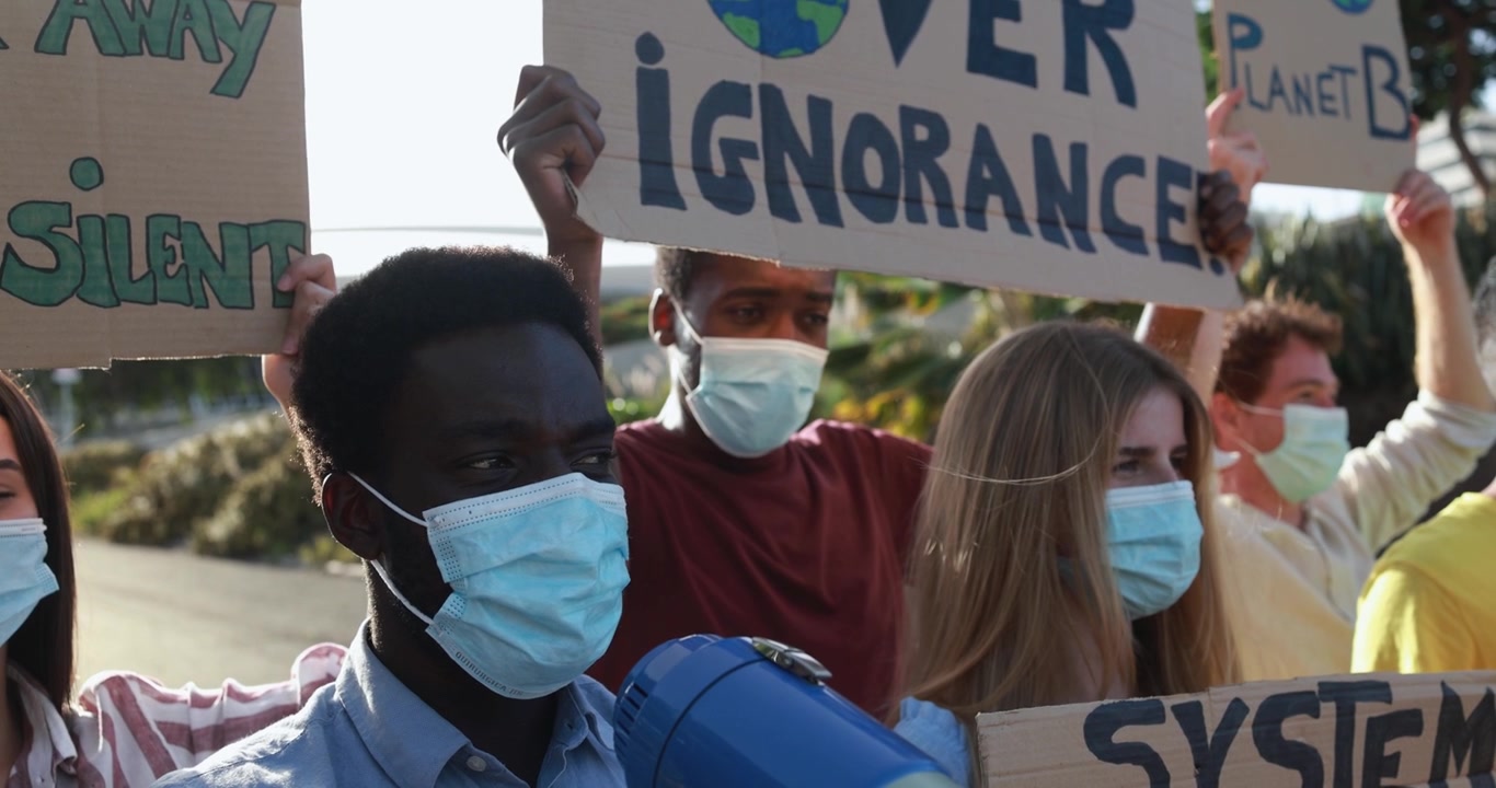 Youth Activists in Face Masks Protesting with Signs and Megaphone