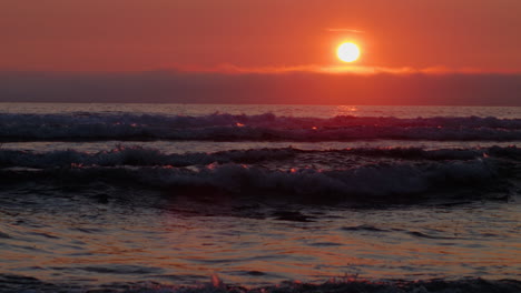 waves coming in to beach at sunset