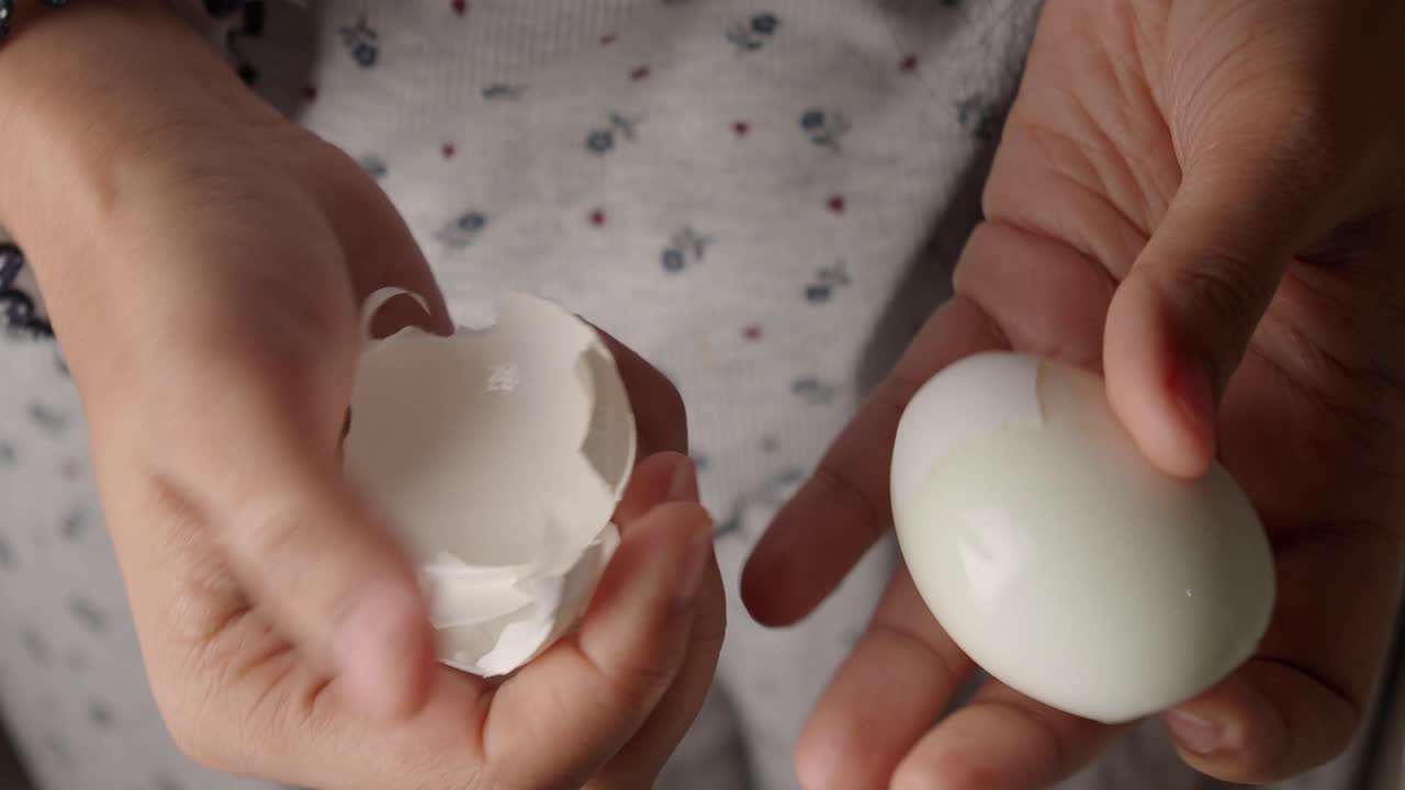 Hands peeling a hard-boiled egg