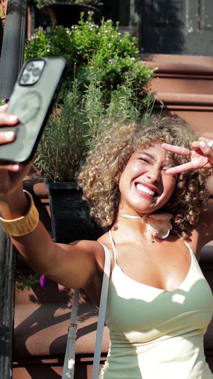 Giovane donna che si scatta selfie con lo smartphone all'aperto