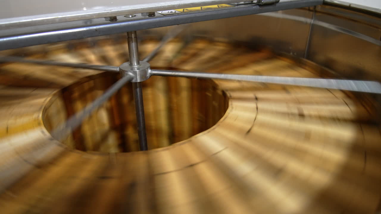 Honey frames are rotated in the centrifuge. Close up. Removal of fresh harvest of honey in the extractor machine.