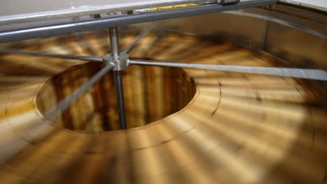 honey frames are rotated in the centrifuge. close up. removal of fresh harvest of honey in the extractor machine.