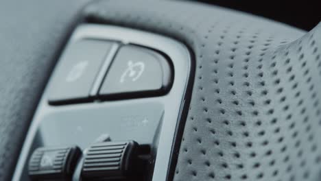 primer plano del botón de control en el volante del coche. vista detallada de un volante de un coche moderno.