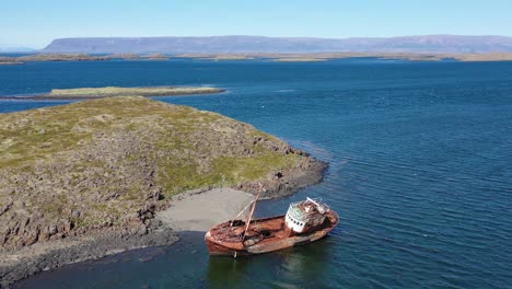 aerial over abandoned fishing boat sitting on the shore of the westfjords iceland