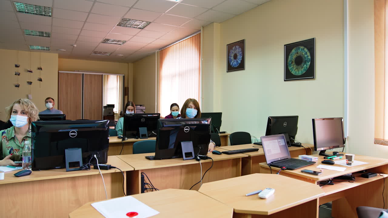 Course on ophthalmology in the modern university. Students wearing masks sit at the desks in front of computers.