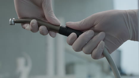 close up on nurse hands assembling dental tool