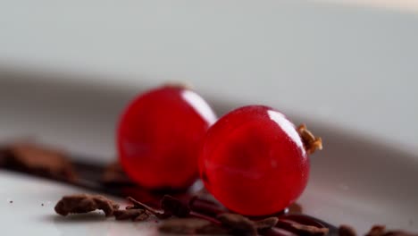 a person catches a cherry from a plate for decoration, close up shot, insert shot