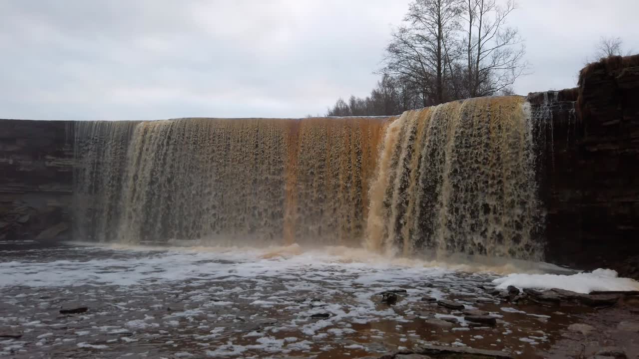 estonia, espectacular cascada jägala desde la vista frontal en un día nublado y temprano en el invierno