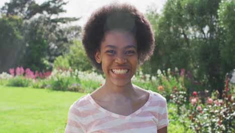 Portrait-of-smiling-african-american-teenage-girl-in-sunny-garden