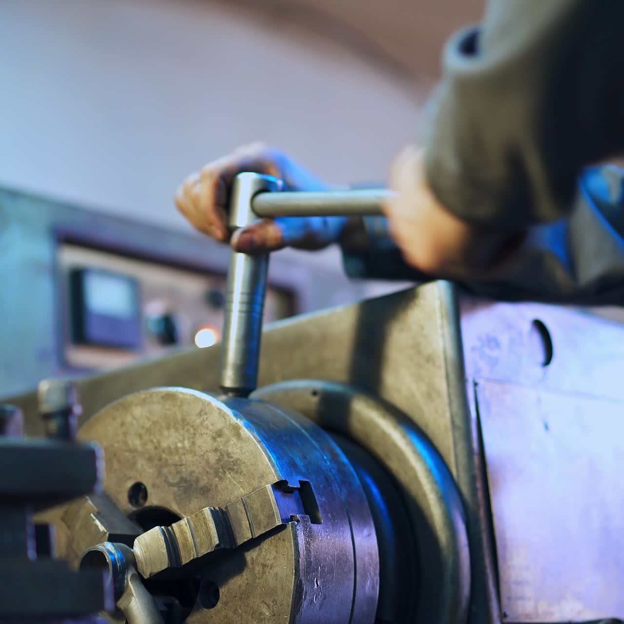 Hands of a turner applying lathe wrench. Man tuning turning lathe to work. Close up