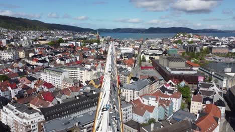 Moving-forward-along-the-boom-of-construction-crane---Beautiful-Bergen-city-aerial-view-in-background