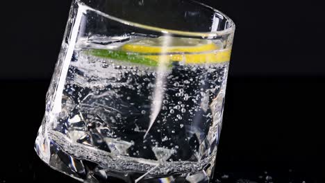 a detailed view of a sparkling drink with lime and lemon slices in a crystal glass.