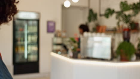 woman welcoming customers into her cafe