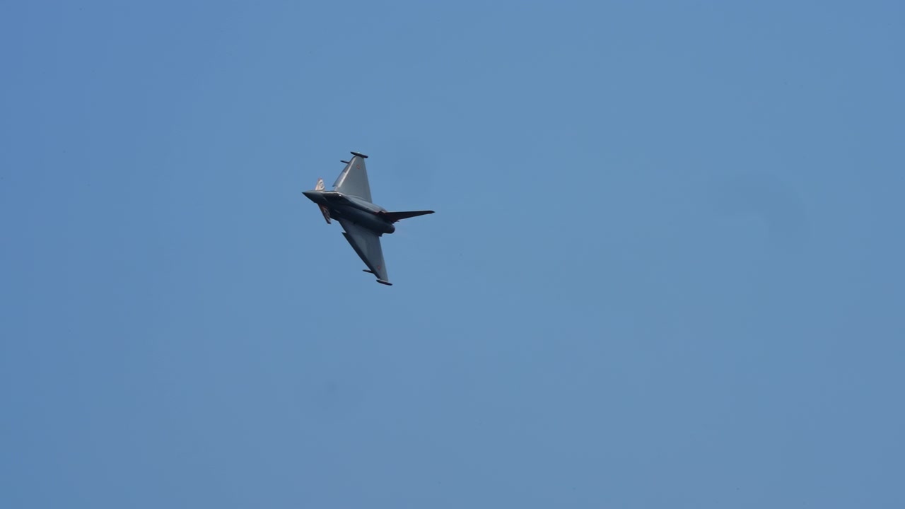 Kampfjet fliegt eine Kurve über blauem Himmel