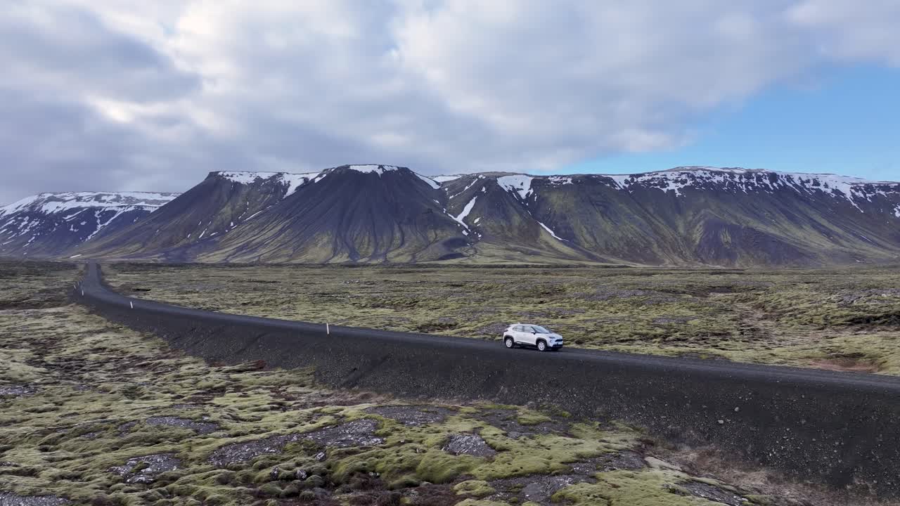 아이슬란드 고지대는 모스, 언덕, 광활한 평야를 가로질러 휘어지는 도로로 차로 통과되며, 멀리 있는 바다는 숨을  수 있는 풍경을 만니다.