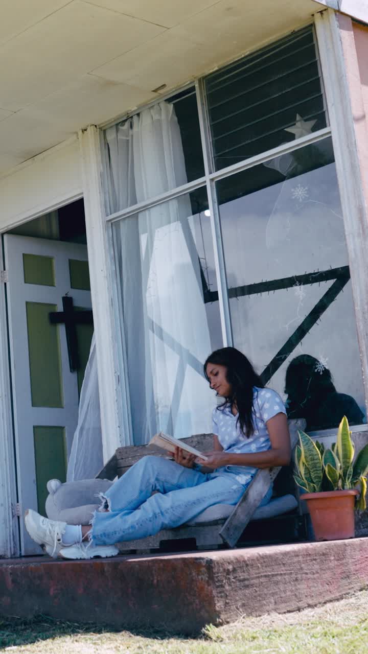 Young Woman Reading a Book on a Porch
