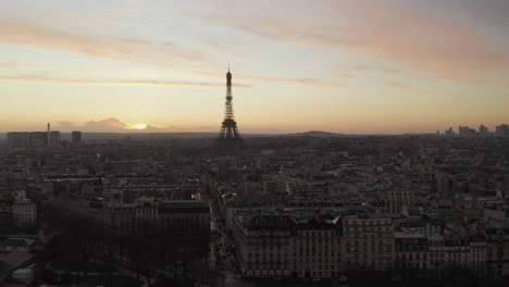Silhouette-of-Eiffel-Tower-against-sunset-sky.-Forwards-fly-above-town-development-at-dusk.-Paris,-France
