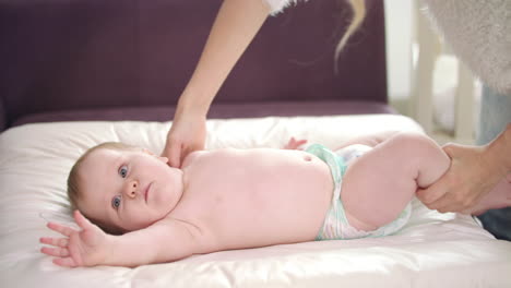 mujer preparando al niño para cambiarle el pañal