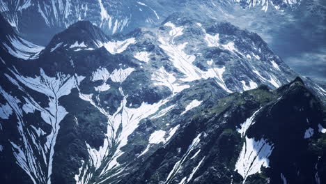 Antena-Sobre-El-Valle-Con-Montañas-Cubiertas-De-Nieve-En-La-Distancia