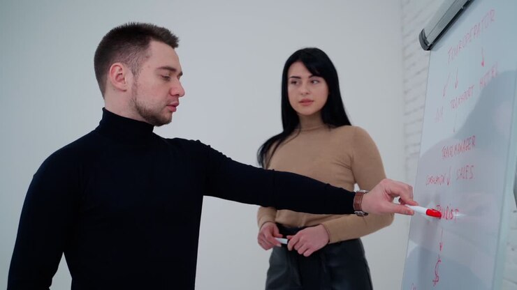 Experienced couple presenting new ideas. Young businessman presenting data idea marketing on a board. Freelance concept. Slow motion.