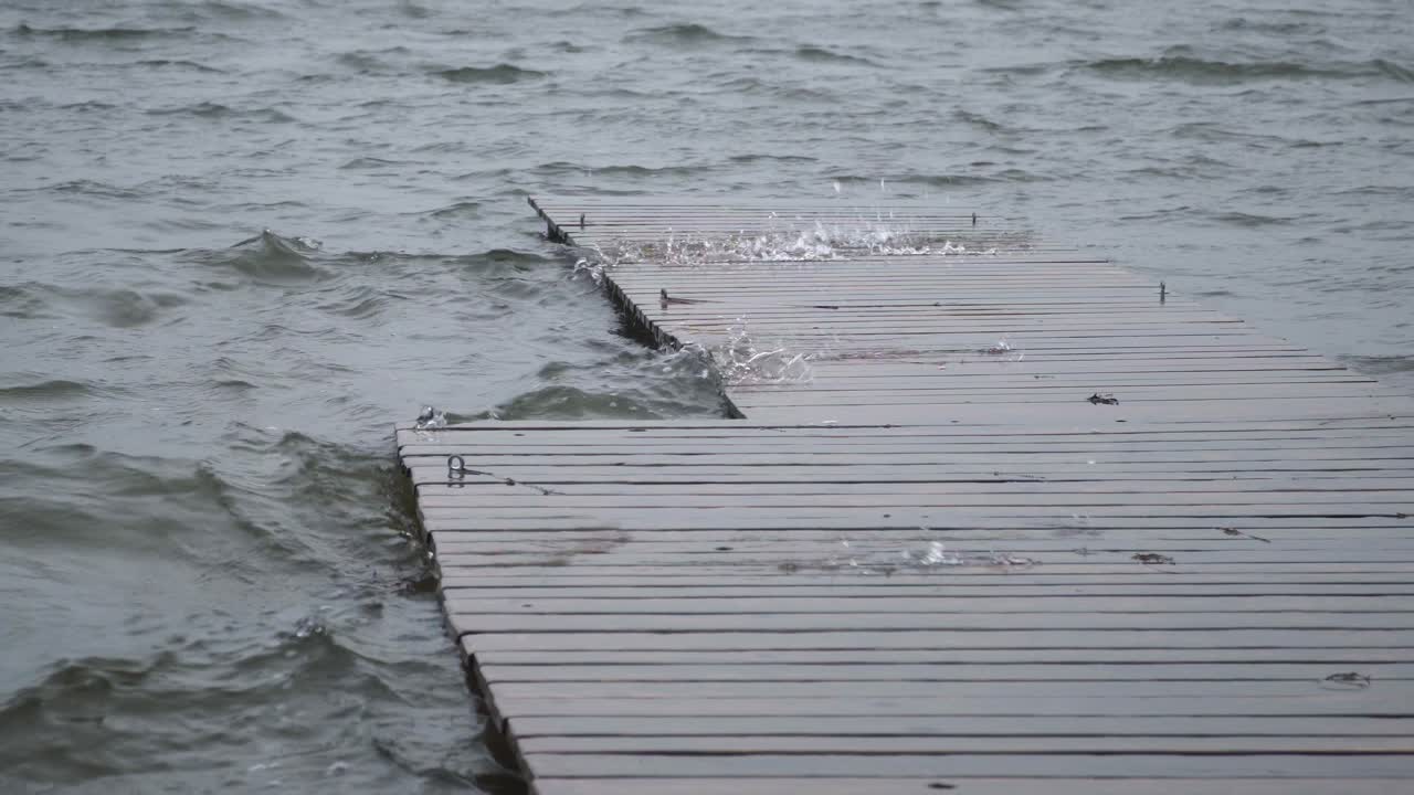 Close up view of lake water playfully jumping out through the wooden deck