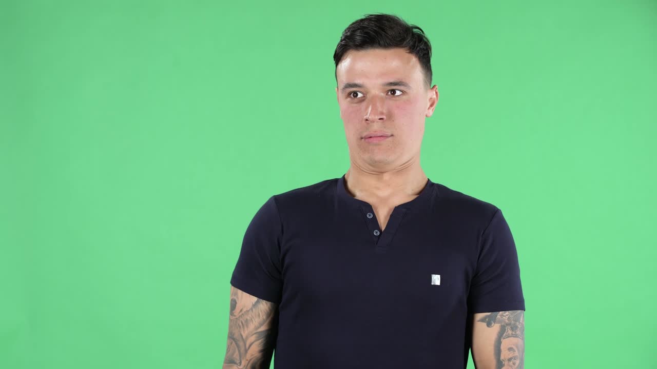 예쁜 젊은 남자의 초상화는 주위를 둘러보며 우프라고 말하고 혼란스러워합니다. 녹색 화면