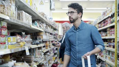 young man choosing goods in grocery store