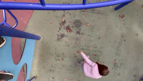 girl-swinging-on-the-bars-of-a-playground