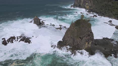power of ocean hitting rocky shore, aerial view