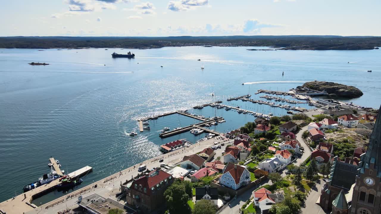 스웨덴 스카게라크 해협의 잔잔한 바다에서 보트와 바지선이 순항하는 리세킬 북쪽 항구