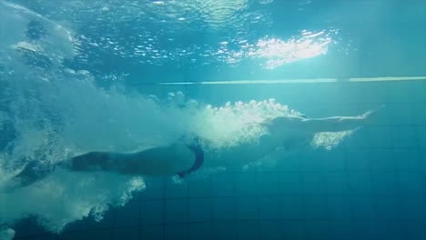 underwater view of man swimming and diving