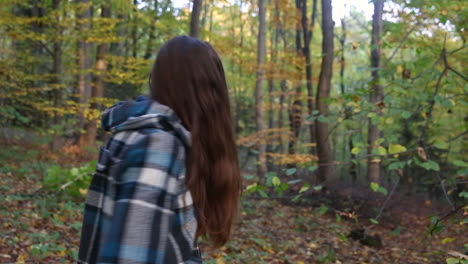 Long-haired-young-woman-with-no-makeup-smiling-on-nature-background