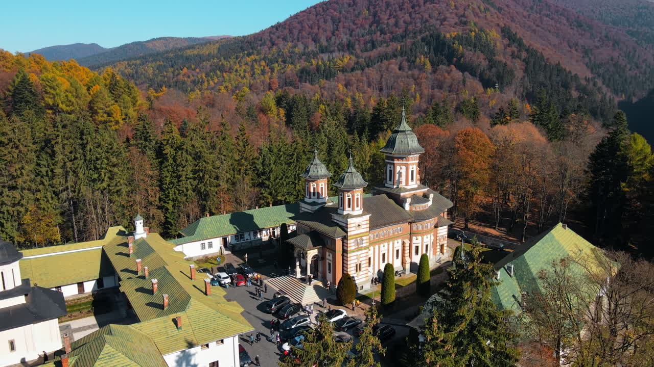 Lotniczy widok z drona na Klasztor w Sinaia w Rumunii. Klasztor w Karpatach z wewnętrznym dziedzińcem, kościołem, turystami i otaczającym go lasem