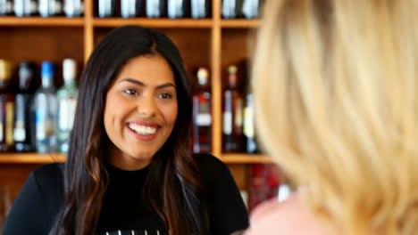 beautiful waitress serving wine to customer at counter 4k