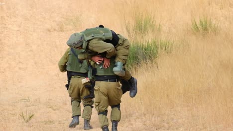 a combat soldier carries his friend on his back after being injured and runs up the hill towards rescue