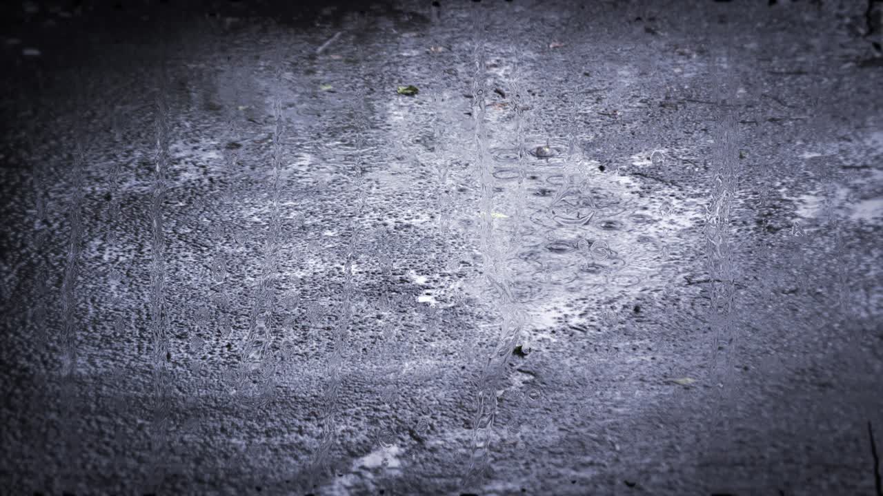 Heavy rain shower downpour cloudburst rainfall behind the glass.
