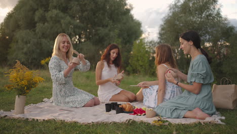 Young women in nature in the field in the park together sculpt clay with tools tap clay products with shovels. they communicate share their impressions. Joint creativity a common hobby.