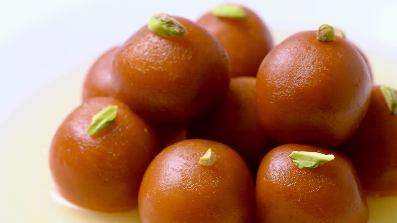 Gulab jamun rotante con granella di pistacchio (dolce indiano) | Dessert