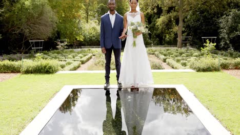 Retrato-De-Felices-Novios-Afroamericanos-En-Su-Boda-En-Un-Jardín-Soleado,-Cámara-Lenta