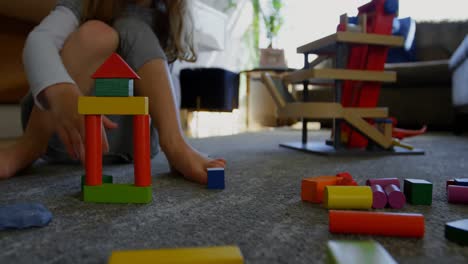 girl playing with building blocks in living room 4k