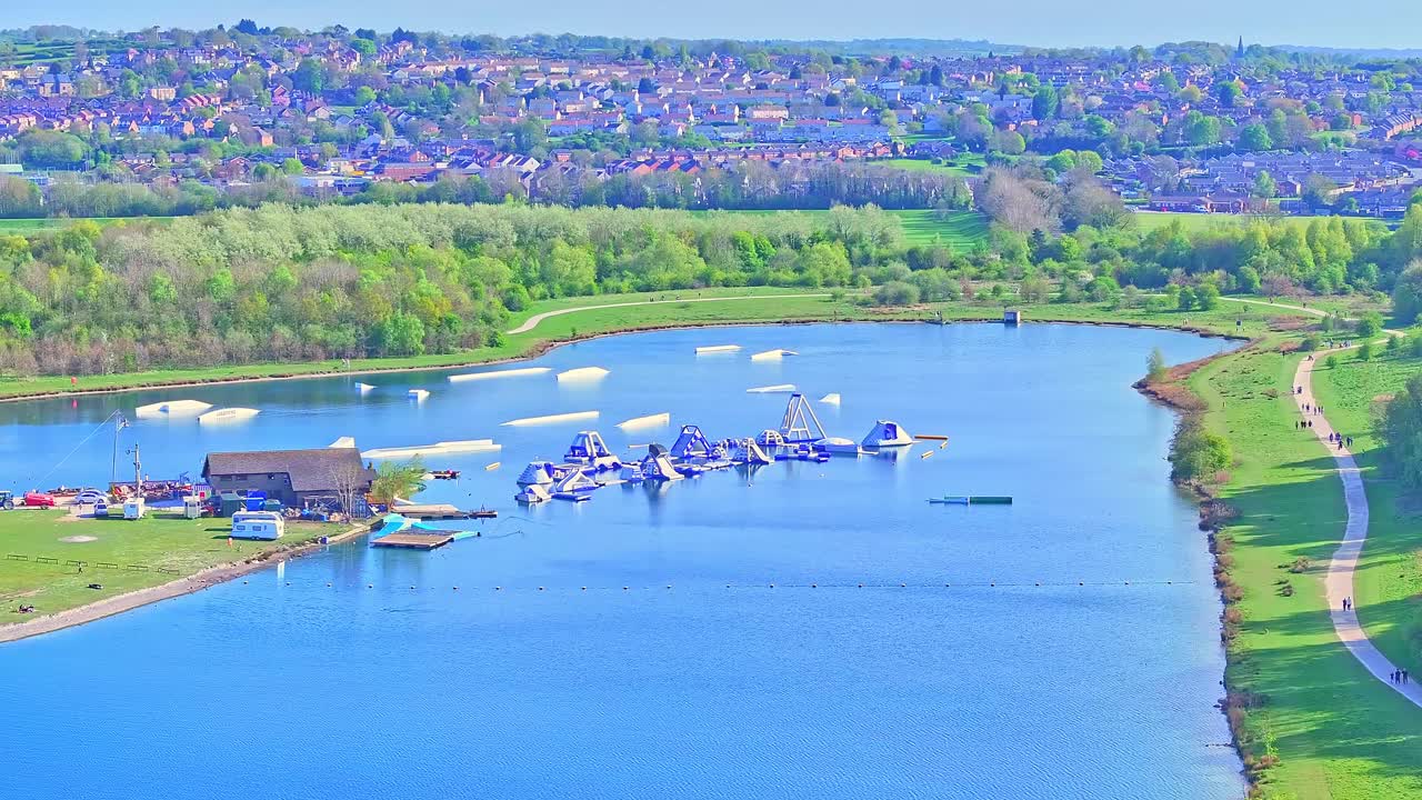 Pan drone shot of aquatic fun park on the lake during the day in Rother Valley Country Park in the Metropolitan Borough of Rotherham, South Yorkshire, England